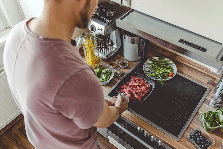 Hombre cocinando en cocina de vitrocer&aacute;mica