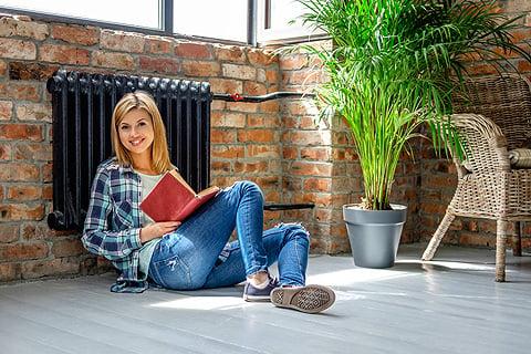 mujer leyendo apoyada en el radiador
